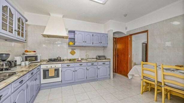 A kitchen with a stove, microwave, and various appliances.