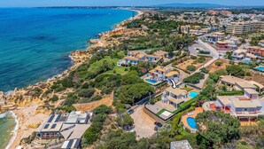 Uma área residencial costeira com casas, praia e uma grande massa de água.