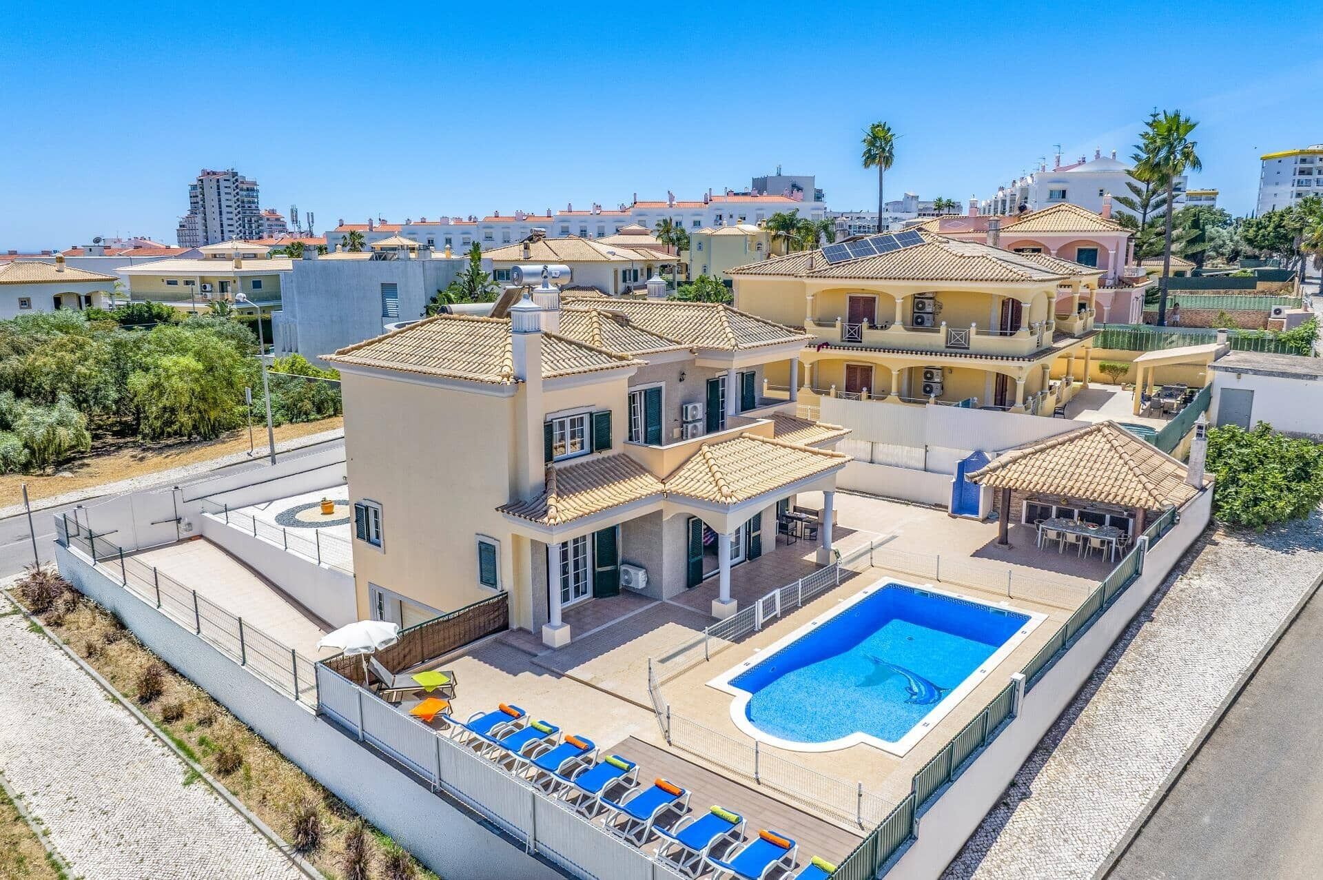 A multi-story residential building with a rooftop pool and sun loungers.