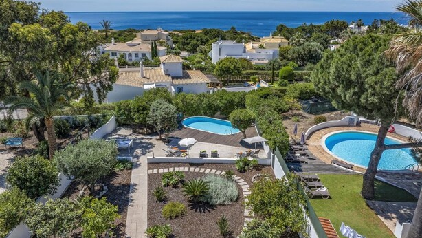 A resort with multiple swimming pools, lush landscaping, and a view of the ocean. - Villa Sawadi by Villa Plus (Praia do Carvoeiro)