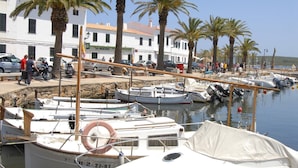 A marina with boats docked, palm trees, and a white building with a sign reading "SA NOSTRA". - Villa Casa Feliz by Villa Plus (Son Parc)