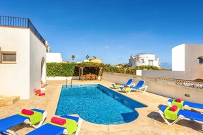 A swimming pool with lounge chairs and a pergola. - Villa Claudia by Villa Plus (S'Algar)