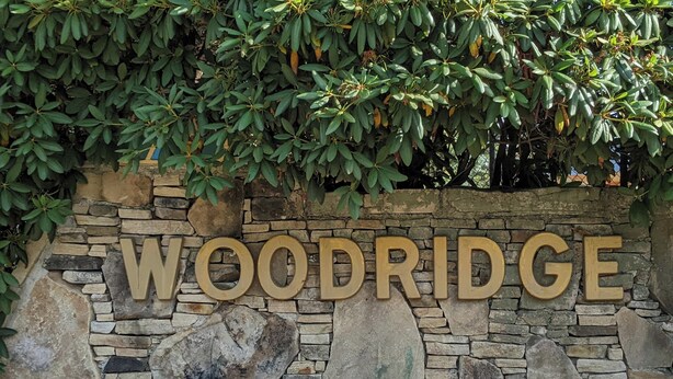 A stone wall with the word "WOODRIDGE" in large letters. - Beautiful Townhouse in The Villages of 7 Springs
 (Champion)