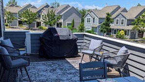 A deck with outdoor furniture, a grill, and a view of neighboring houses. - Beautiful Townhouse in The Villages of 7 Springs
 (Champion)