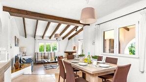 Un comedor con una mesa de madera, sillas marrones y una lámpara colgante.