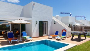 A poolside area with lounge chairs and a pool. - Villa Torrenit by Villa Plus (Alayor)