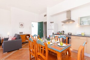 A modern apartment with a dining area, kitchen, and living room. - Villa Torresoli by Villa Plus (Alayor)