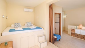 Ein Schlafzimmer mit Bett, Kleiderschrank, Badezimmer und einer Treppe.