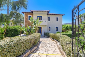 A two-story building with a stone pathway leading to the entrance.