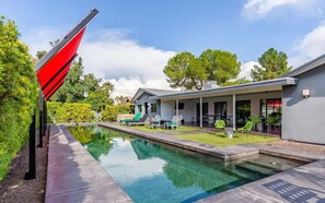 A modern house with a swimming pool, outdoor seating, and a red sculpture. - Designer 5 Bd Home/Fountain Pool/ Spa/ Game Patio (Phoenix)