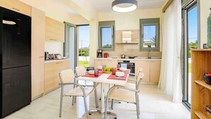 Una cocina moderna con zona de comedor, ventanas amplias y vistas al exterior.