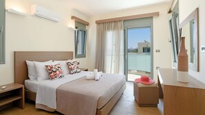 A modern hotel room with a large bed, a bedside table, a dresser, and a balcony with a view.