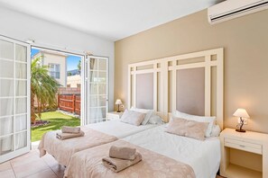 Een hotelkamer met twee bedden, een groot raam en een airconditioning.