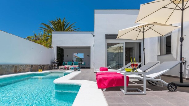 A modern outdoor pool area with a clear blue pool, lounge chairs, and a bar area. - Villa Colibri by Villa Plus (Palm-Mar)