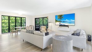 A spacious living room with a large window, a dining area, and a comfortable seating arrangement. - Sunset Captiva 10 (Captiva)