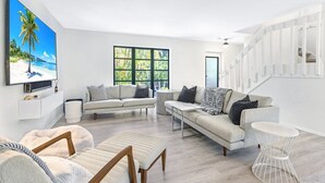 A modern living room with two sofas, a coffee table, and a TV mounted on the wall. - Sunset Captiva 10 (Captiva)