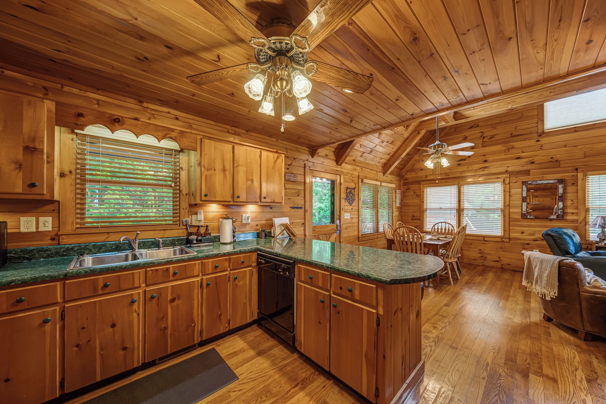 A spacious kitchen with wooden cabinets, a central island, and a ceiling fan.