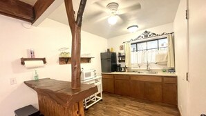 A kitchen with wooden cabinets, a microwave, a refrigerator, and a wooden island. - Sunrise Suite - Sierra Mountain Lodge (Ahwahnee)