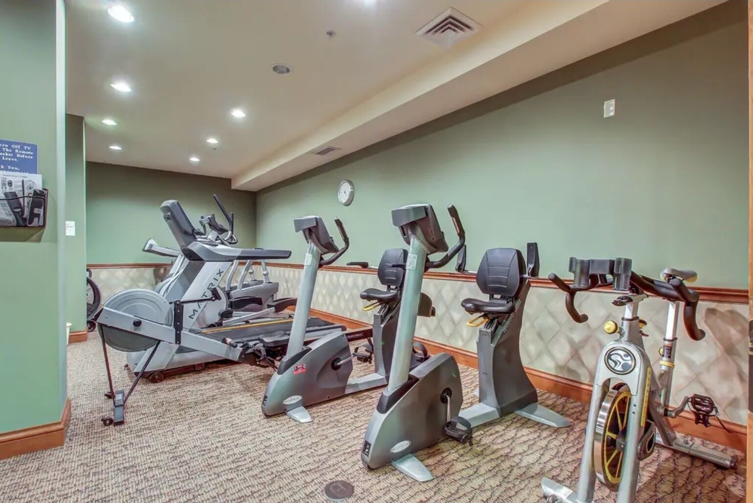 A fitness center with treadmills, elliptical machines, and stationary bikes.