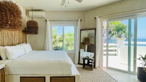 A bedroom with a bed, a ceiling fan, a large window, and a view of the ocean. - TULUM Beachfront 20min from hotel zone <br>Housekeeping - amazing food (Tulum)