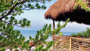 A beach view with a thatched-roof structure and a wooden fence. - TULUM Beachfront 20min from hotel zone <br>Housekeeping - amazing food (Tulum)