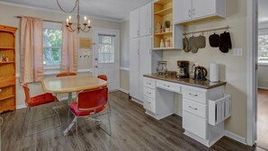 A compact kitchen with a dining table, chairs, a coffee maker, and a chandelier. - White Oak 4BR @ Patterson Place (Durham)