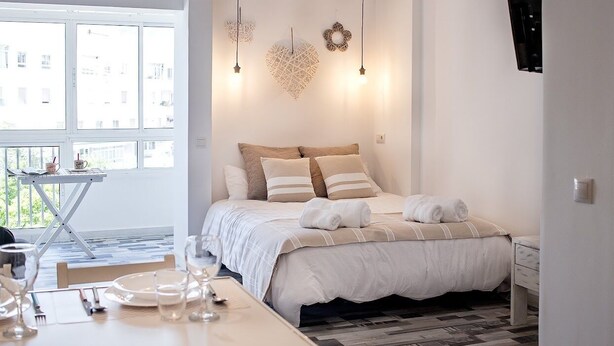 Une chambre à coucher avec un lit, une table de chevet et une vue sur l’extérieur.