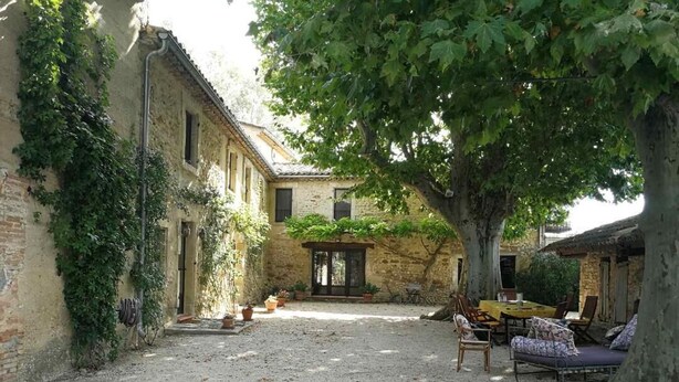 A courtyard with a gravel ground, a tree, and a building with a door and windows. - Family home amidst vineyards in Drôme provençale (TULETTE)