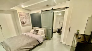 Une chambre à coucher moderne avec un lit, un bureau et un téléviseur.
