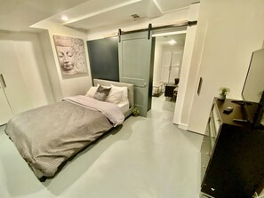 A modern bedroom with a bed, a desk, and a TV. - SPACIOUS GARDEN OASIS IN THE HEART OF DC! WALKABLE TO IT ALL! (Washington)