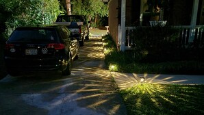 A residential driveway with parked cars and a house with a porch. - ADA King near Crabtree, PNC Arena, State Fairgrounds, NCMA (Raleigh)