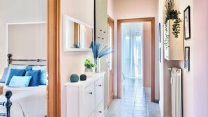 Une chambre à coucher avec un lit, une commode et un couloir menant à une porte.