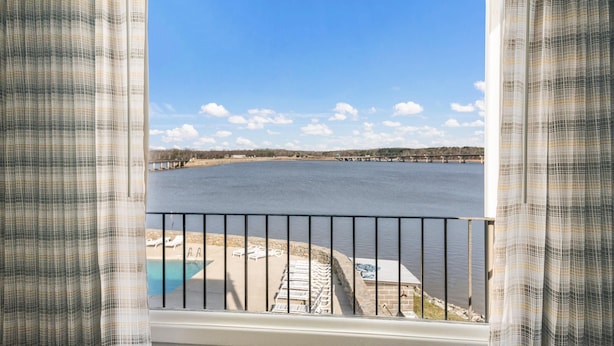 A view from a balcony with a pool, a bridge in the distance, and a clear sky. - Quality Inn - On The Lake Clarksville-Boydton  (Clarksville)