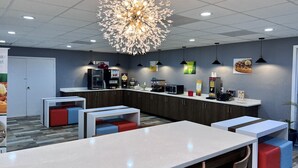A modern kitchen area with a central island, seating, and various appliances.