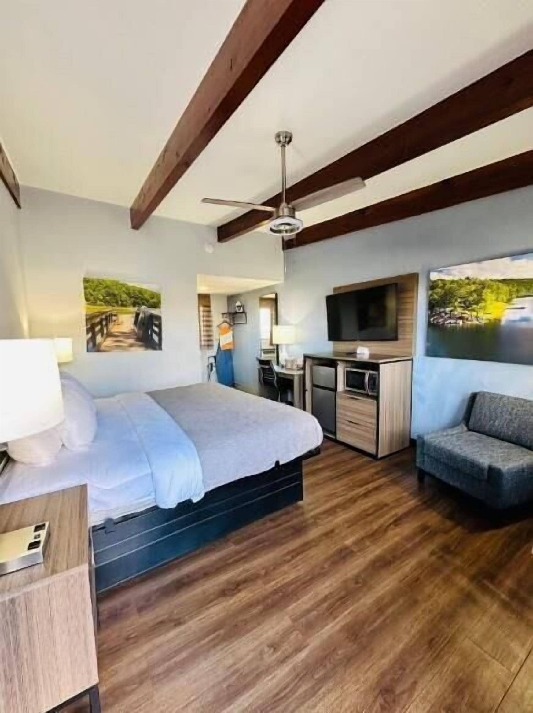 Ein Schlafzimmer mit Bett, Schreibtisch und Fernseher.