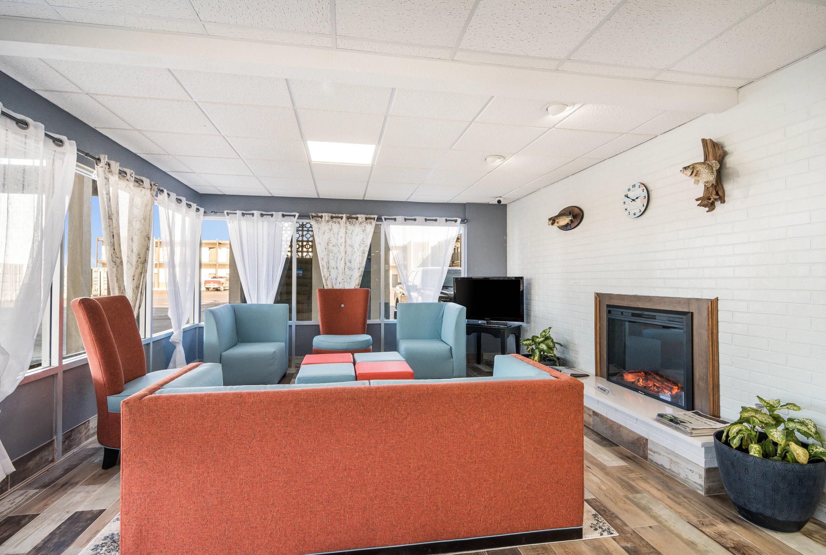 Una sala de estar moderna con chimenea, asientos cómodos y una televisión.