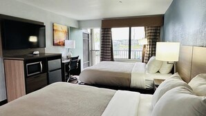 A hotel room with two beds, a desk with a TV, a lamp, and a view of the outside. - Quality Inn - On The Lake Clarksville-Boydton  (Clarksville)
