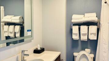 A bathroom with a sink, mirror, toilet, and towel rack.
