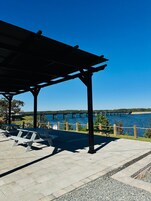 Un área de picnic techada con bancos y vistas a un puente sobre el agua.