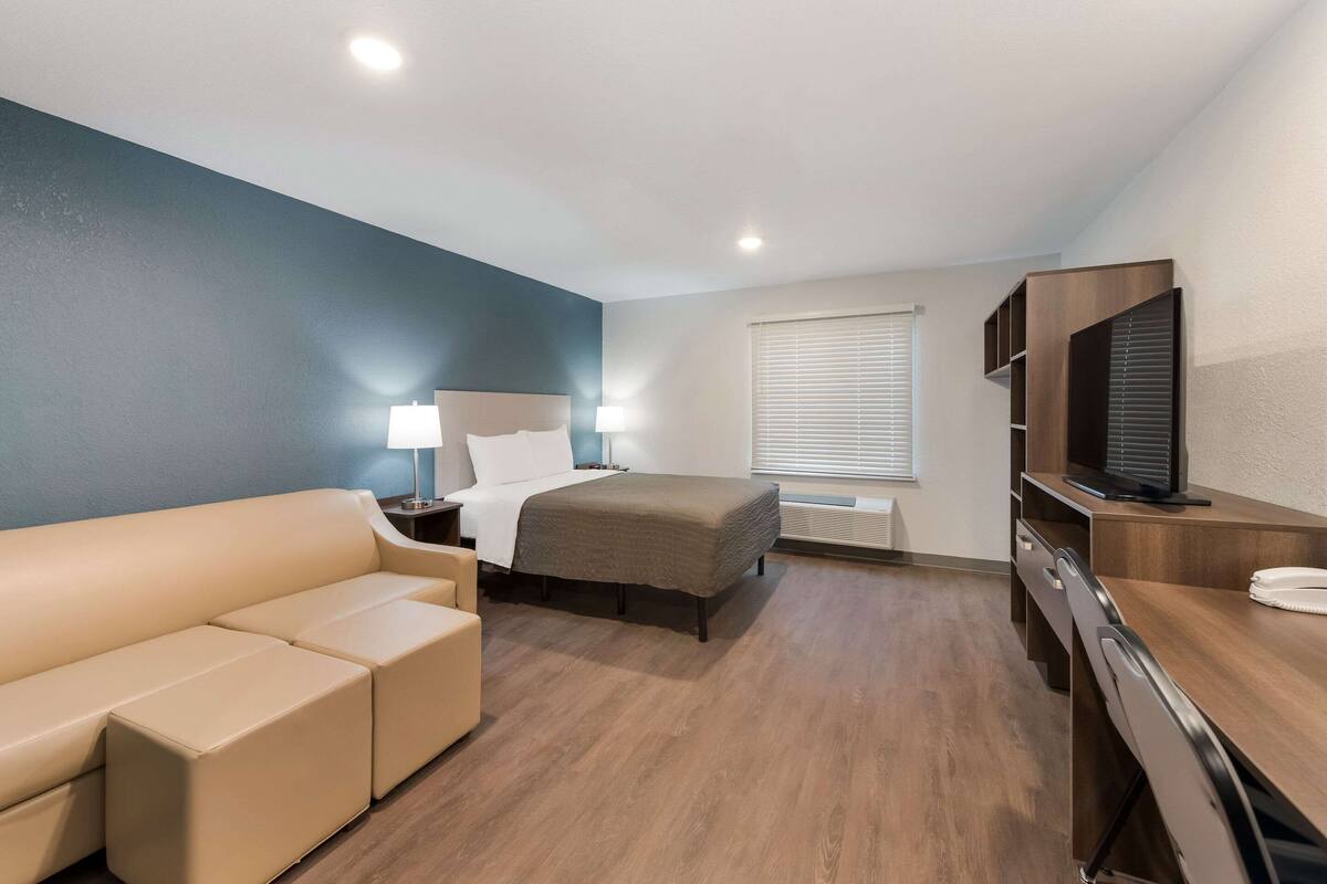 Une chambre d’hôtel moderne équipée d’un lit, d’un canapé, d’un bureau et d’une télévision.