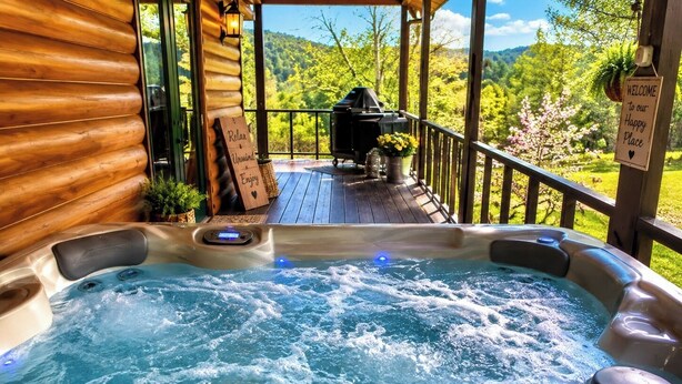 A hot tub on a wooden deck with a view of a forest and mountains.