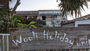 Un panneau en bois portant l’inscription « Wooli Holiday unit », indiquant un établissement proposant des hébergements de vacances.