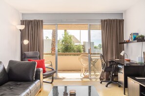 Relax in a comfortable seating area with a sofa and enjoy the view from the balcony through the sliding glass door.