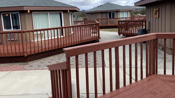 A hotel with a wooden deck and a covered outdoor area.