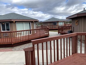 A hotel with a wooden deck and a covered outdoor area. - Room with TWO Double-sized Beds, Pets OK with Additional Fee (Terrebonne)