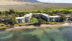 Un hotel sulla costa con diversi edifici, una spiaggia e acque cristalline.