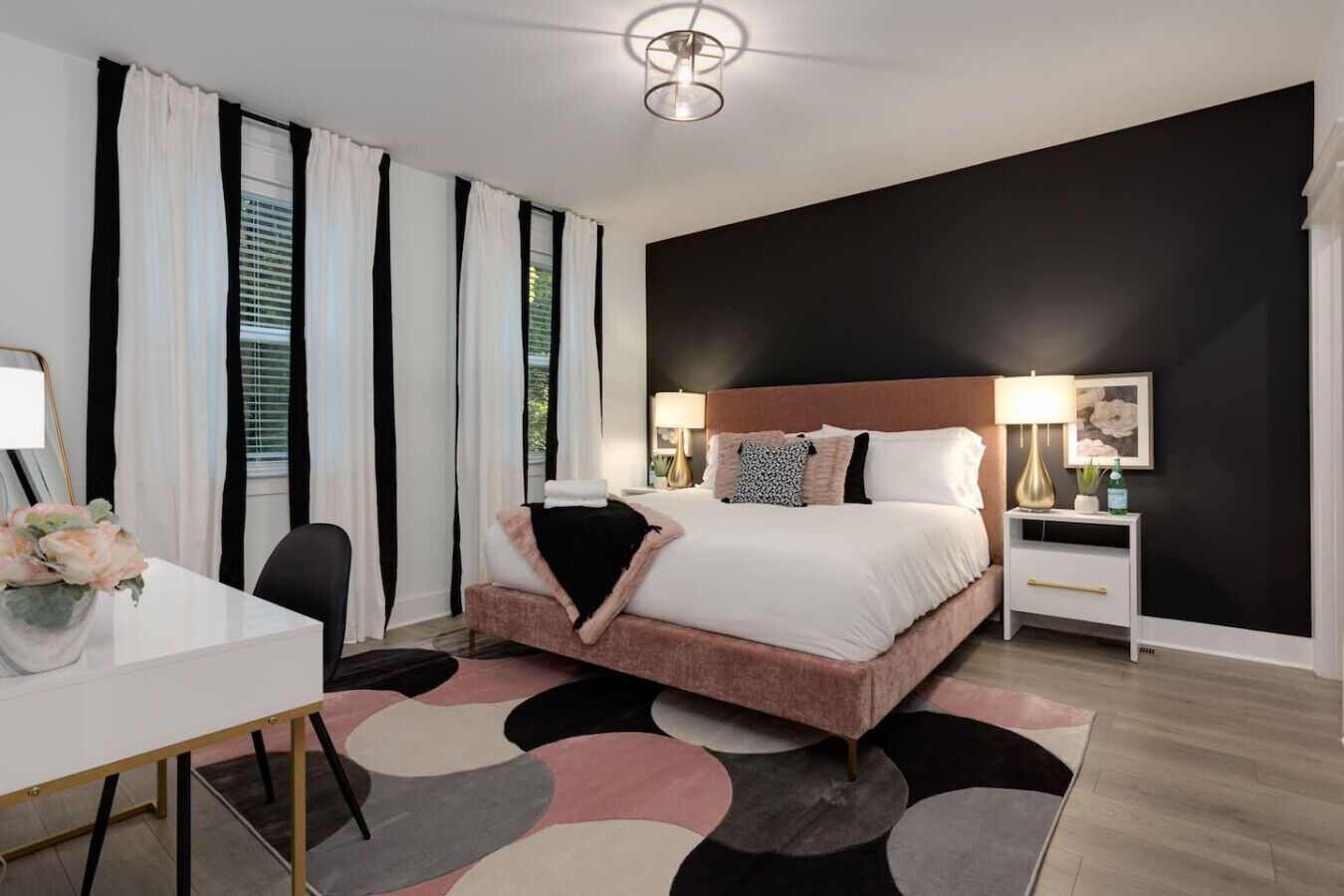 Ein modernes Schlafzimmer mit einem großen Bett, Nachttischen, einem Schreibtisch und einem Stuhl.