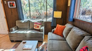 Ein gemütliches Wohnzimmer mit einer Couch, einem Couchtisch und einem Teppich.