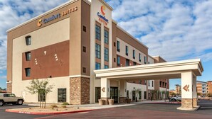 A Comfort Suites hotel with a modern design, featuring a covered entrance and a parking lot.