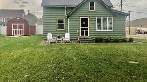 A two-story house with a front porch, a small garden, and a mailbox. - The Franklin Green House in the heart of Berne, Indiana (Berne)